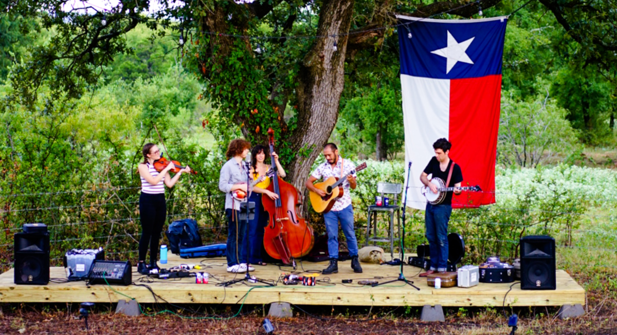 a band playing live music with a texas state flag in the background